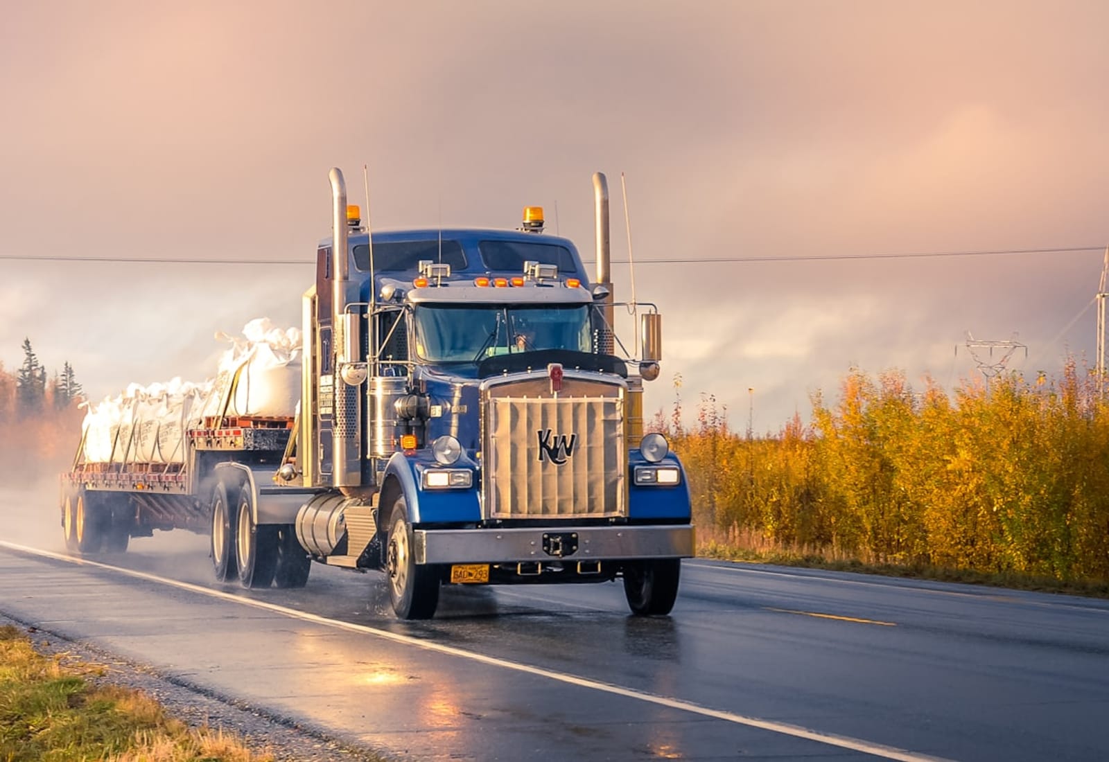Auto-transport hauler on a highway at golden hour