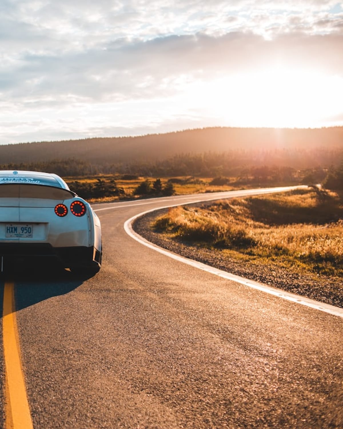 Vehicle on an open road at sunset
