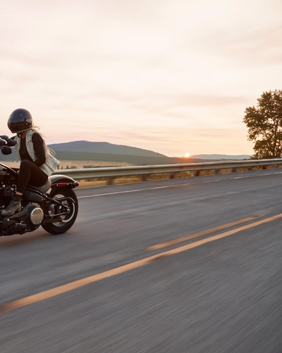 Motorcycle being ridden on a highway at sunset
